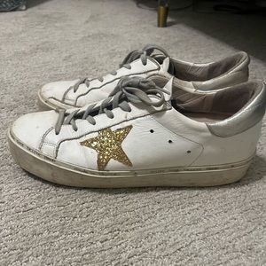 Golden Goose Hi Star in white with a gold star and silver backing.